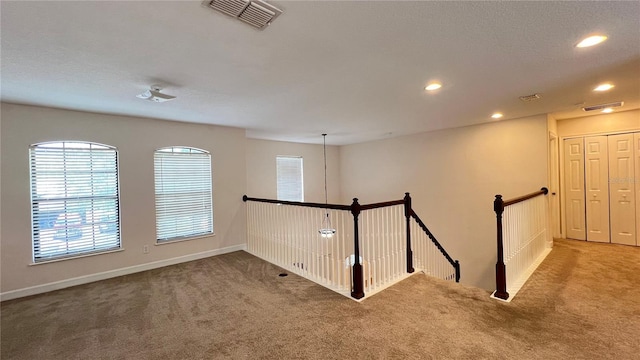 hallway featuring carpet floors and a textured ceiling