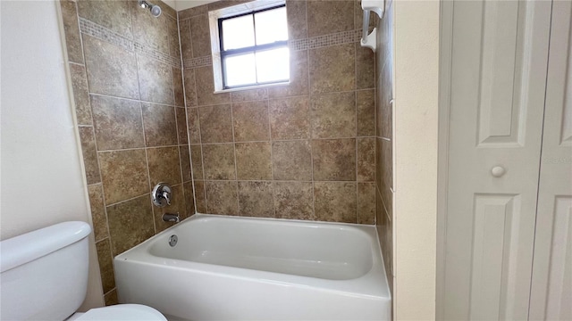 bathroom featuring tiled shower / bath and toilet