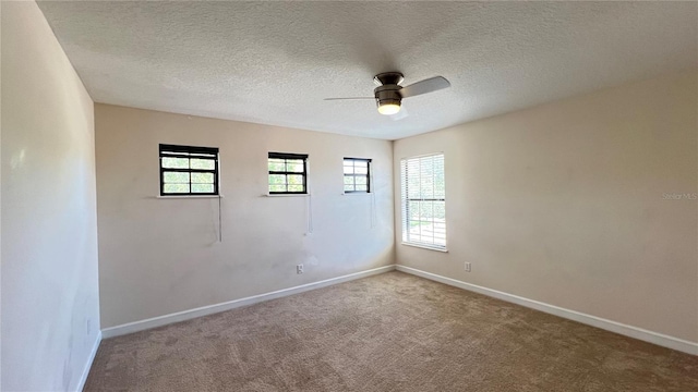 spare room with a textured ceiling, carpet flooring, and ceiling fan