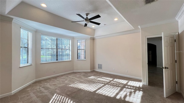 empty room with ceiling fan, a textured ceiling, carpet floors, and ornamental molding