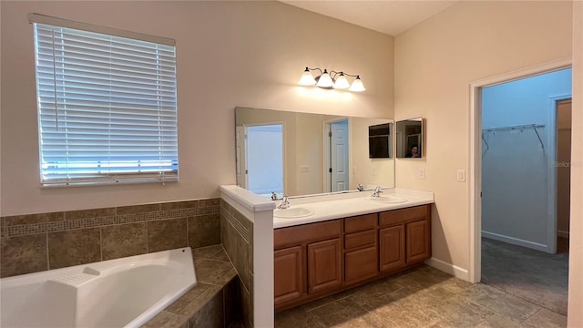 bathroom featuring tiled bath, tile patterned flooring, and vanity