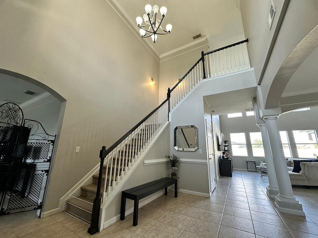 stairs with ornamental molding, a high ceiling, and tile patterned floors