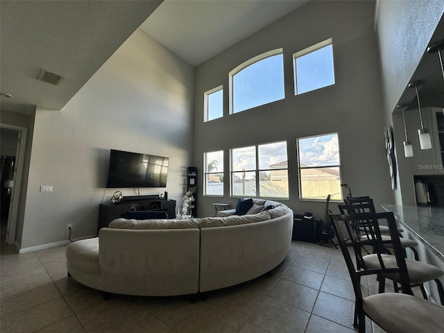 living room with a high ceiling and tile patterned floors