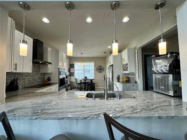 2321 Hinsdale Dr, Kissimmee, FL 34741 - kitchen featuring wall chimney exhaust hood, light stone countertops, backsplash, and recessed lighting