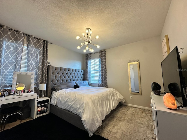 carpeted bedroom with an inviting chandelier and a textured ceiling