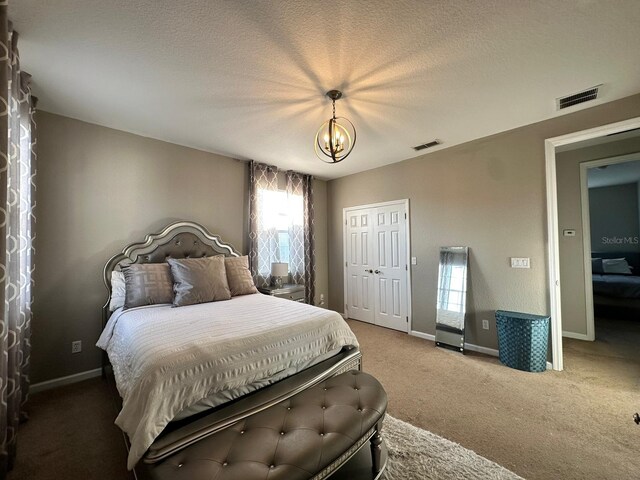 2321 Hinsdale Dr, Kissimmee, FL 34741 - bedroom featuring carpet flooring, a chandelier, a closet, and a textured ceiling