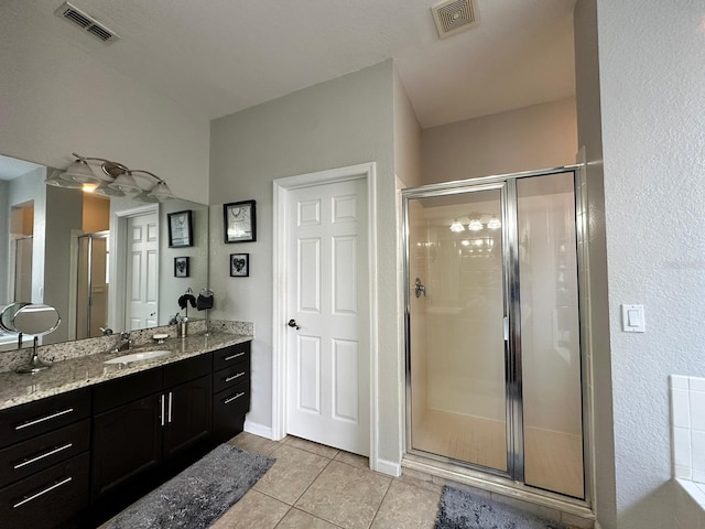 bathroom featuring walk in shower, tile patterned floors, and vanity