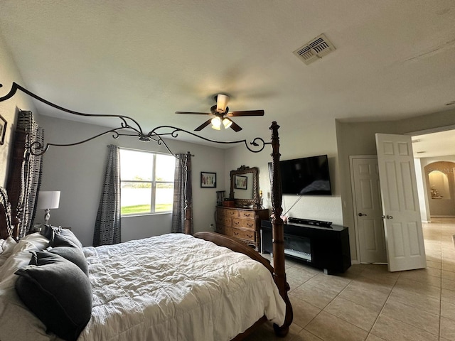 tiled bedroom featuring a textured ceiling and ceiling fan