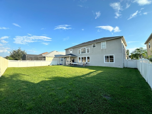 rear view of property featuring a lawn