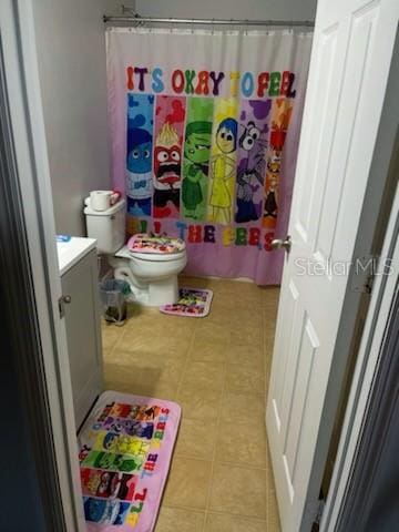 bathroom featuring vanity, walk in shower, and toilet