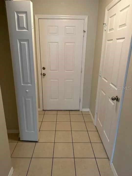 doorway featuring baseboards and light tile patterned floors