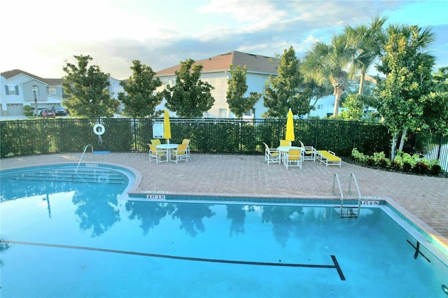 community pool with fence and a patio