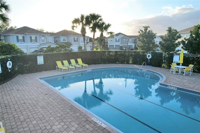 pool featuring a patio, fence, and a residential view
