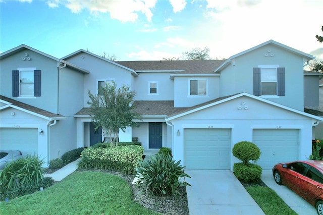 view of front of house featuring a shingled roof, an attached garage, a front lawn, stucco siding, and concrete driveway