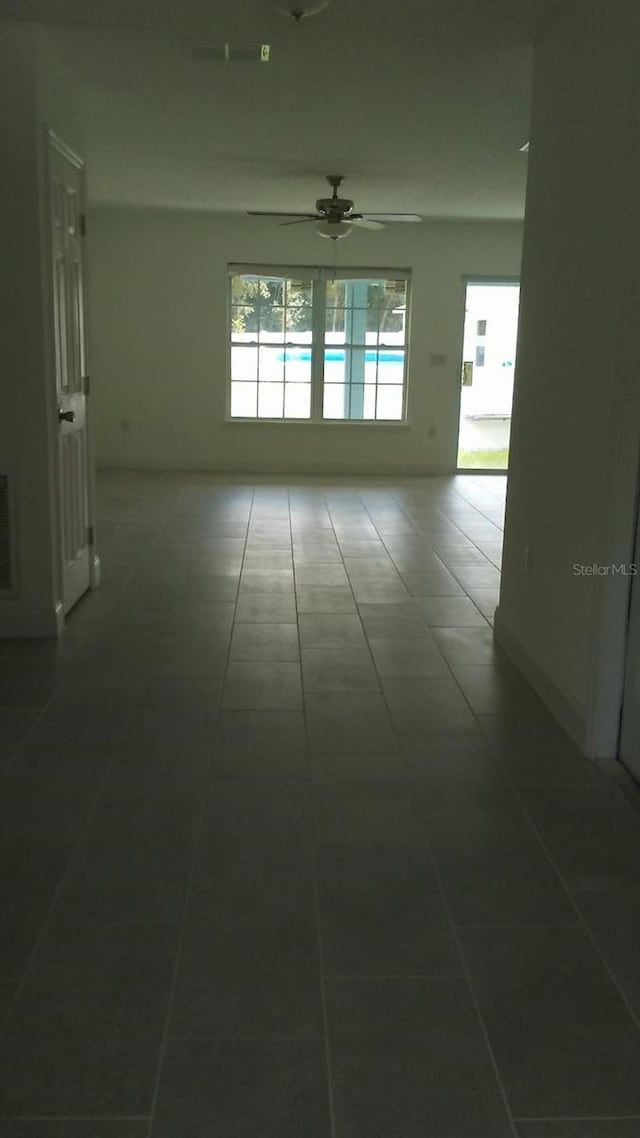 spare room featuring ceiling fan and tile patterned flooring