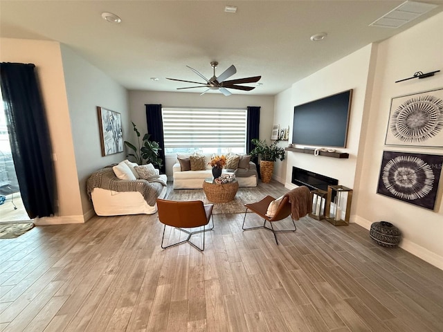 living room featuring ceiling fan and light hardwood / wood-style flooring