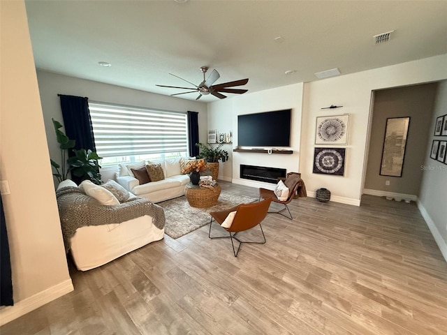 living room featuring ceiling fan and light hardwood / wood-style flooring