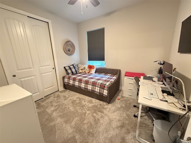 carpeted bedroom featuring ceiling fan and a closet