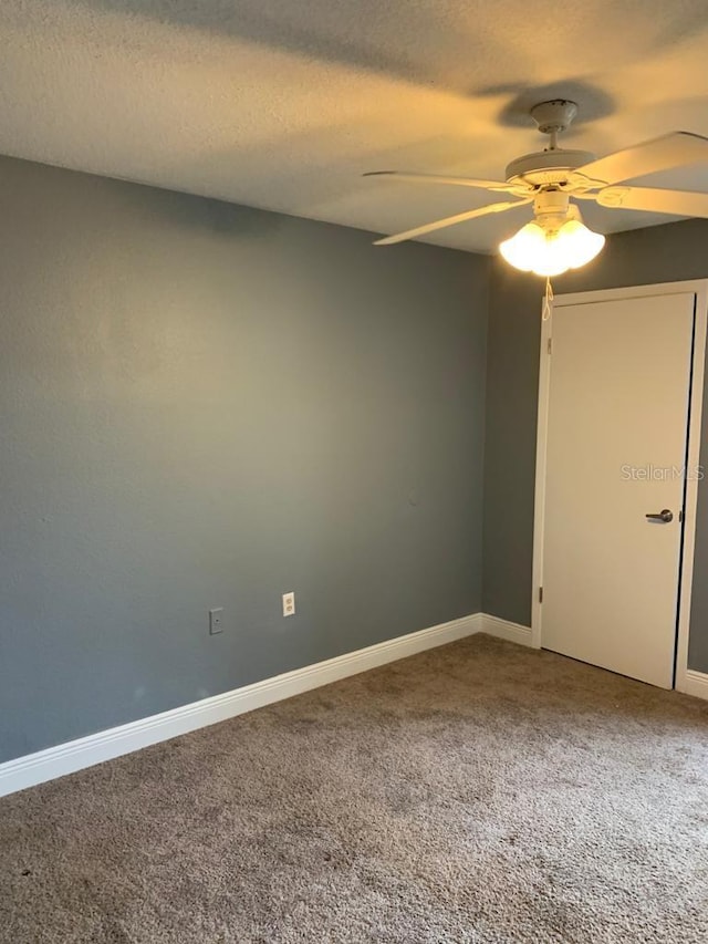 unfurnished room with ceiling fan, carpet floors, and a textured ceiling