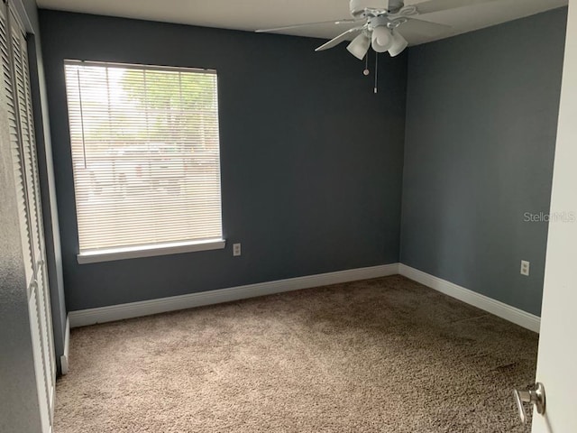 carpeted spare room featuring ceiling fan