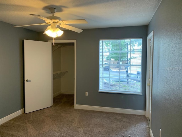 unfurnished bedroom with ceiling fan, a closet, and carpet flooring