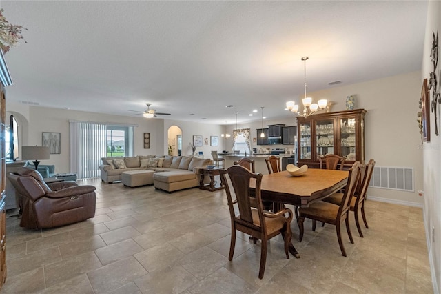 dining room featuring ceiling fan with notable chandelier