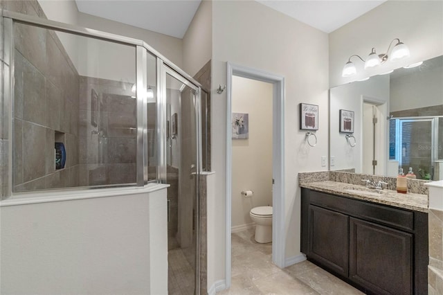 bathroom featuring vanity, a shower with shower door, toilet, and tile patterned floors