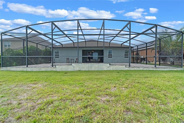 rear view of property featuring a lanai, a patio, and a lawn