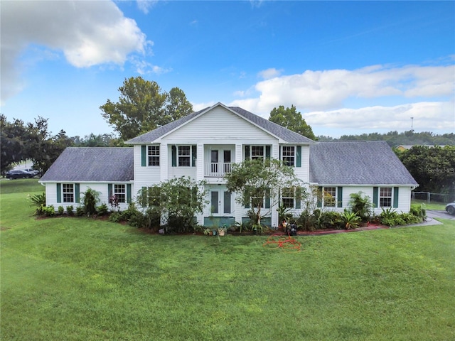 view of front of property featuring a front lawn and a balcony