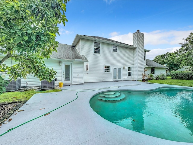 rear view of house with a yard, central AC, and a patio