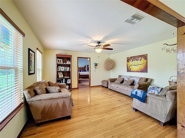 living room featuring a textured ceiling, a healthy amount of sunlight, and light hardwood / wood-style flooring