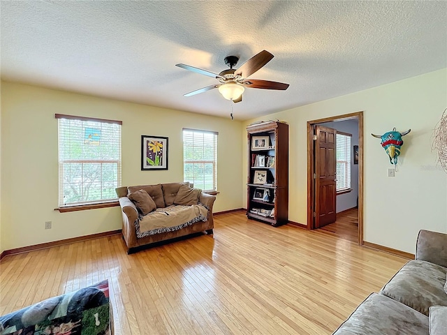 living room featuring a textured ceiling, a healthy amount of sunlight, ceiling fan, and light hardwood / wood-style flooring