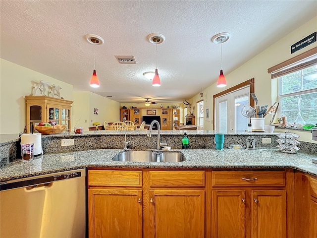 kitchen featuring a textured ceiling, decorative light fixtures, sink, and dishwasher