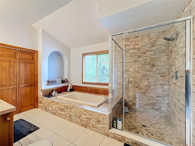 bathroom featuring tile patterned flooring, plus walk in shower, lofted ceiling, vanity, and a textured ceiling