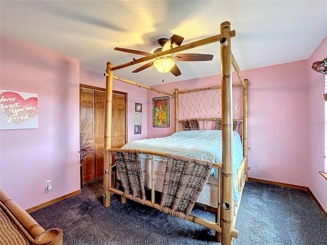 bedroom with dark colored carpet, ceiling fan, two closets, and a textured ceiling