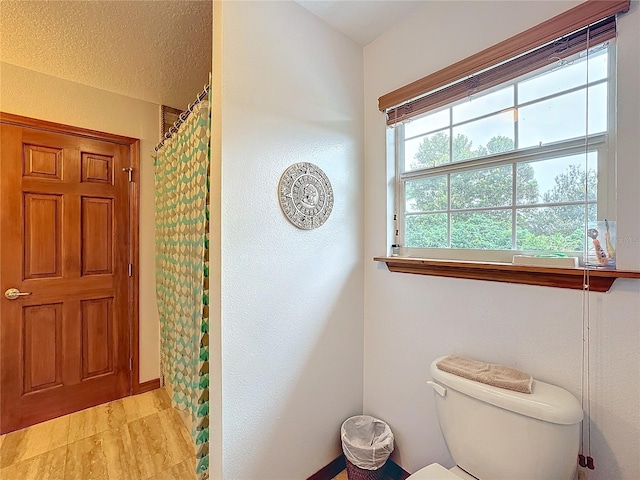 bathroom with curtained shower and toilet