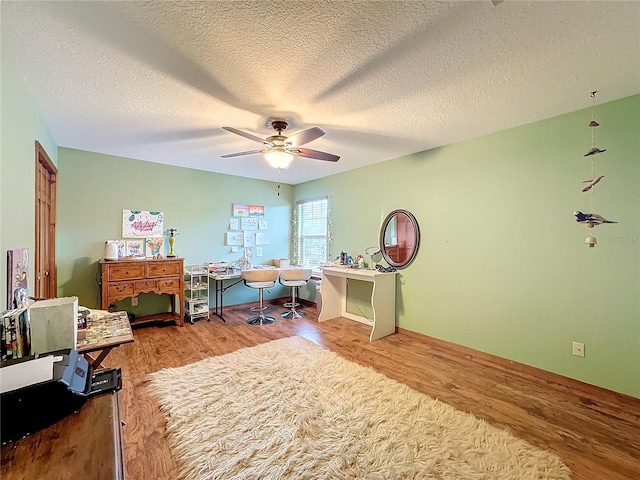 office area featuring ceiling fan, hardwood / wood-style flooring, and a textured ceiling