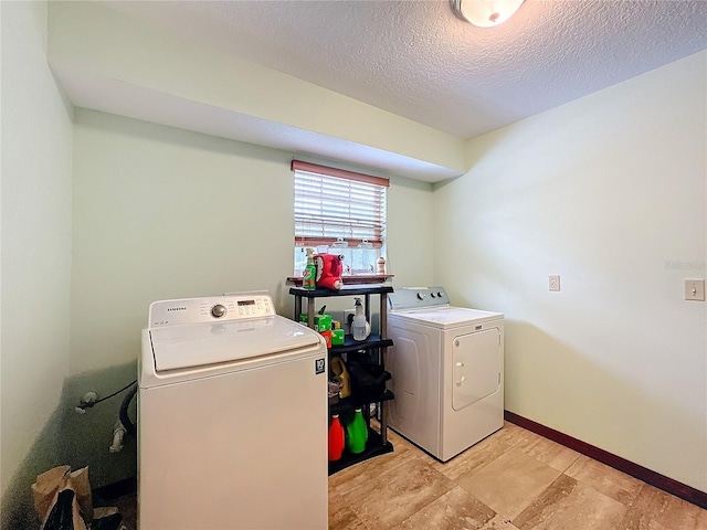 clothes washing area with a textured ceiling and washing machine and dryer