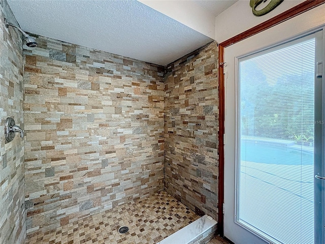 bathroom featuring a tile shower and a textured ceiling