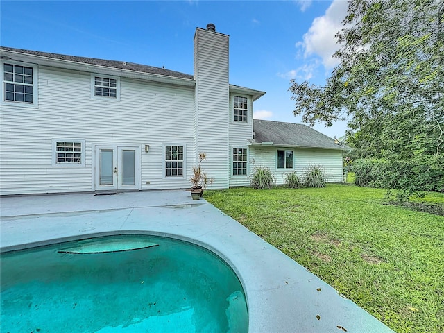 rear view of property with a patio and a yard