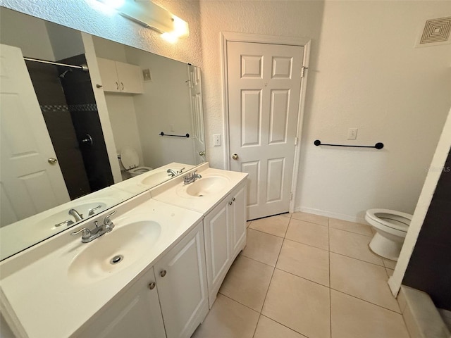 bathroom with tile patterned floors, vanity, and toilet