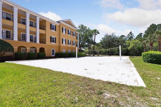 view of property's community featuring a yard and volleyball court