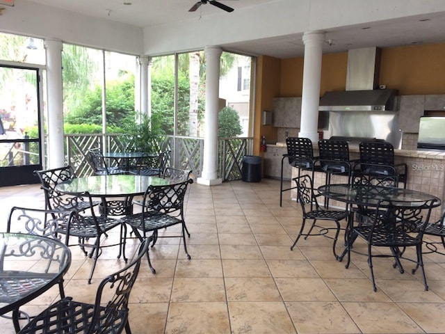 sunroom with decorative columns and ceiling fan