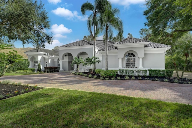 mediterranean / spanish home featuring a front yard