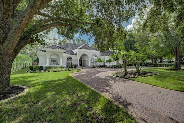 mediterranean / spanish home featuring a front lawn