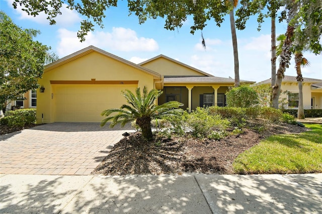 196 Ventana Dr, Kissimmee, FL 34759 - view of front of house featuring a garage, stucco siding, and decorative driveway