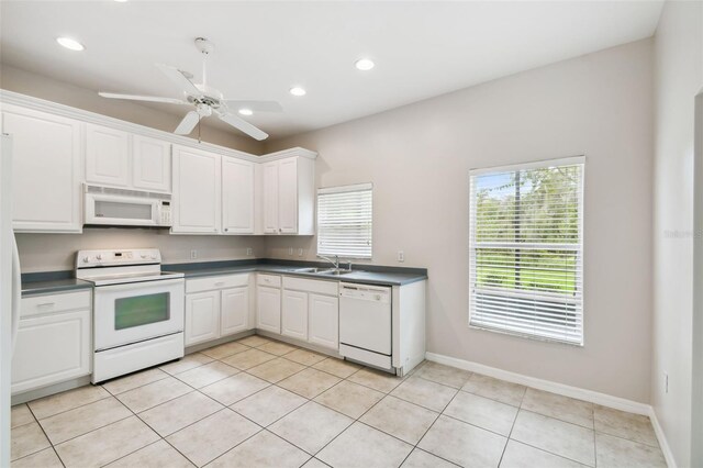 196 Ventana Dr, Kissimmee, FL 34759 - kitchen featuring white appliances, a sink, dark countertops, white cabinetry, and recessed lighting