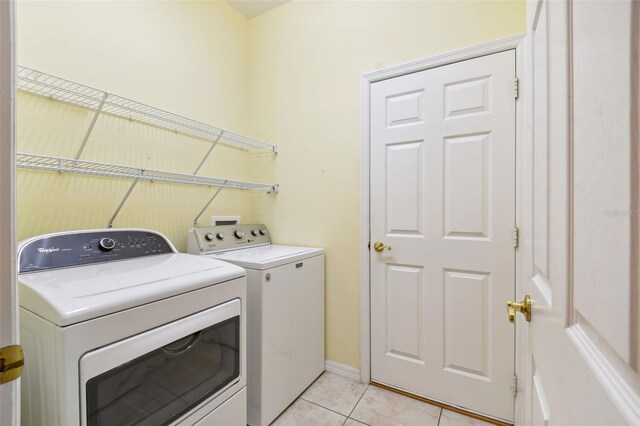 196 Ventana Dr, Kissimmee, FL 34759 - laundry area featuring independent washer and dryer, light tile patterned flooring, and baseboards