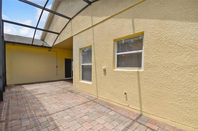 view of patio featuring glass enclosure