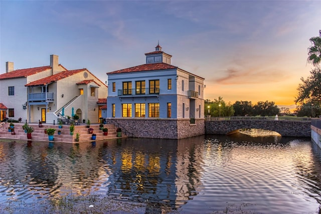 back house at dusk with a water view